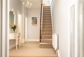 The spacious hallway is split-level, with doors to the cloakroom, bedroom 1 and sitting room. 