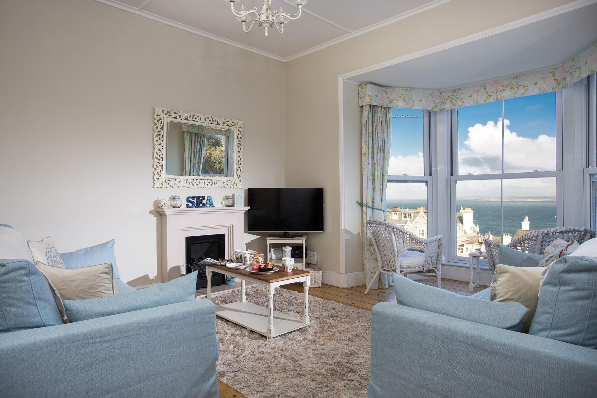 Relax in the sitting room, looking out over the views in the summer or in front of the fire in the colder months. 