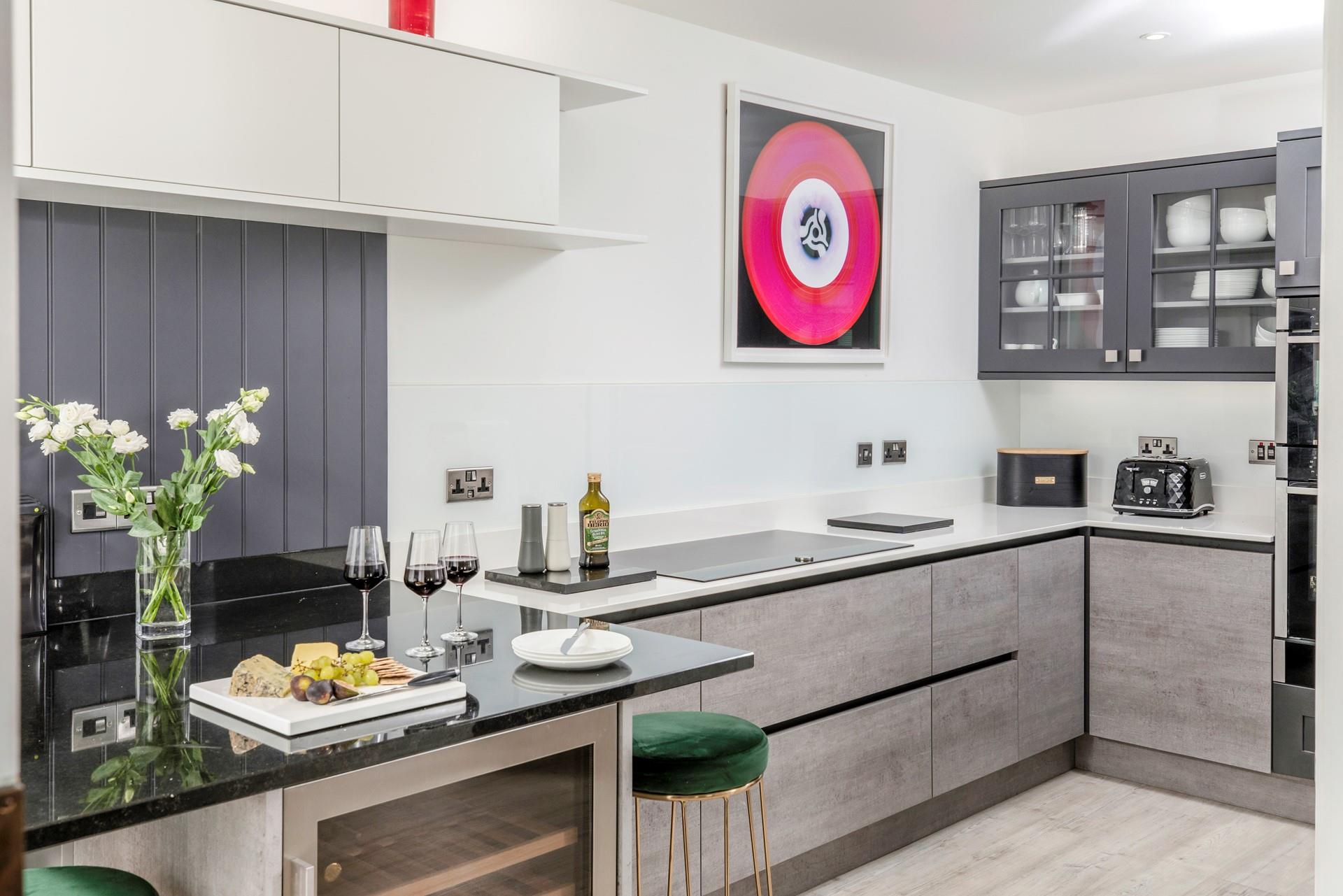 The kitchen blends a cool, modern colour palette with luxurious, rich fabrics, creating a stunning space to cook and eat.