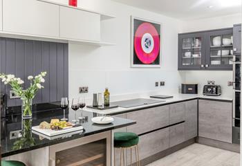 The kitchen blends a cool, modern colour palette with luxurious, rich fabrics, creating a stunning space to cook and eat.