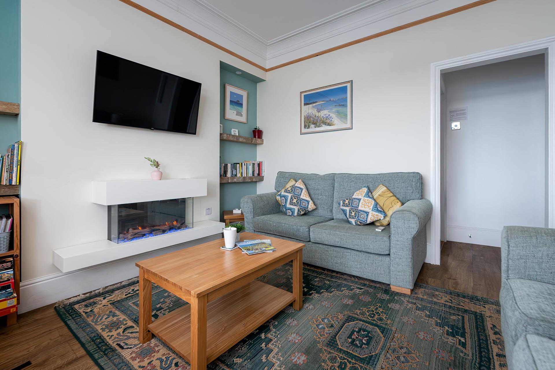 We love the modern fireplace and coastal artwork in the sitting room. 