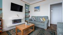 We love the modern fireplace and coastal artwork in the sitting room. 