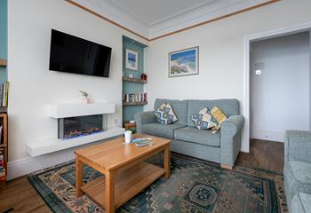 We love the modern fireplace and coastal artwork in the sitting room. 