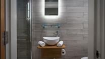 The tranquil shower room offers a rainfall shower for a spa-like experience. 