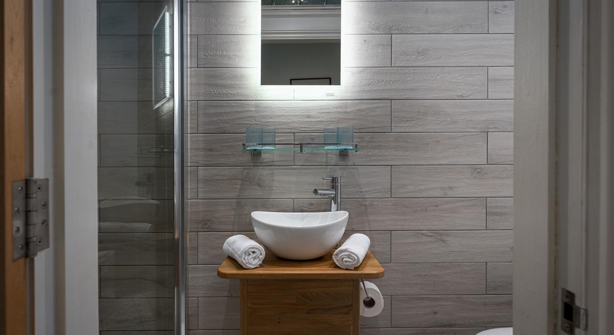 The tranquil shower room offers a rainfall shower for a spa-like experience. 