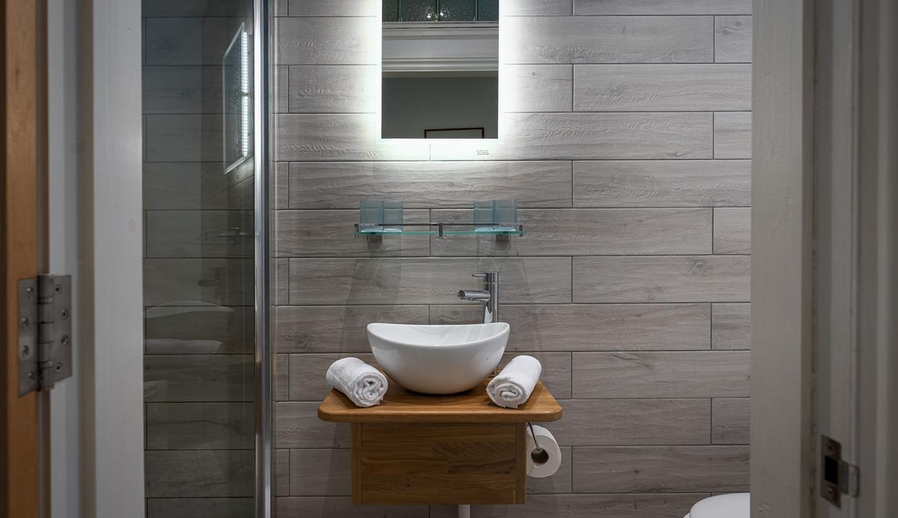 The tranquil shower room offers a rainfall shower for a spa-like experience. 