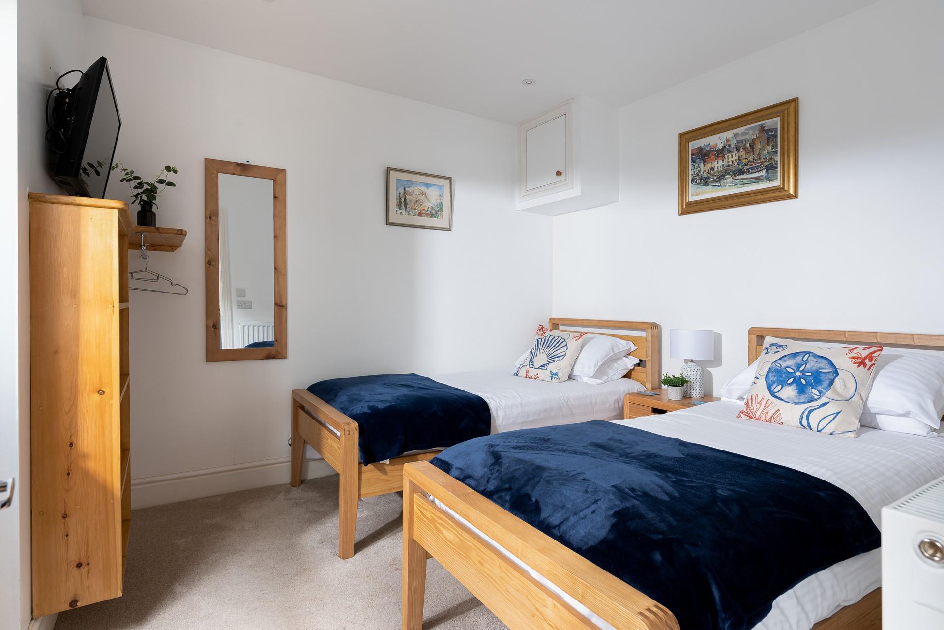 Suitable for children or friends, bedroom 2 offers twin beds and access to the rear courtyard.