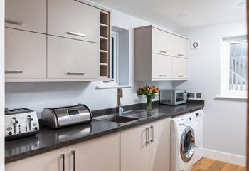 The utility room is well-equipped including a washing machine, tumble dryer, microwave and sink.