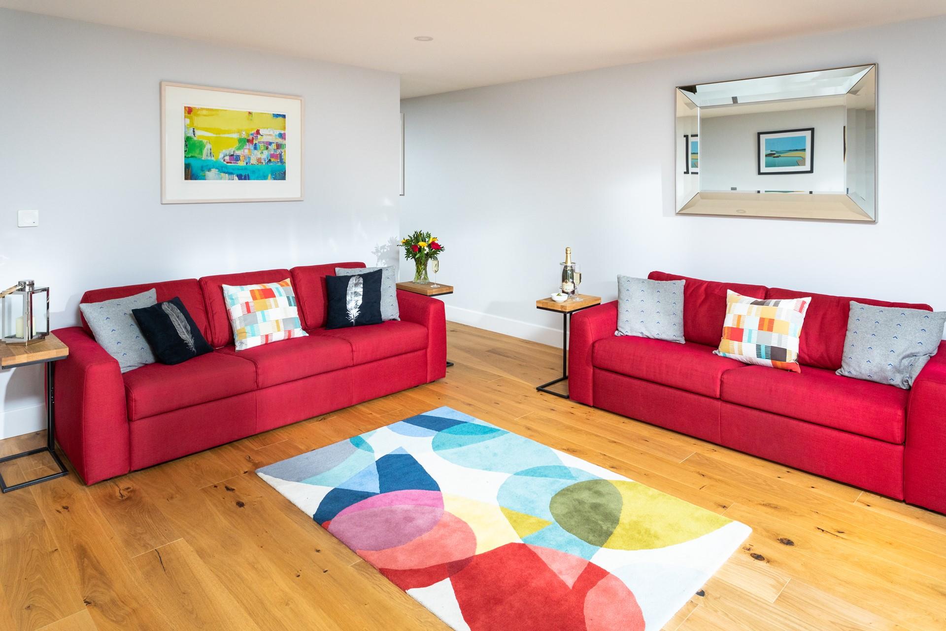 Vibrant textile sofas and an abstract rug and artwork have created a fantastic vibe in the sitting room.