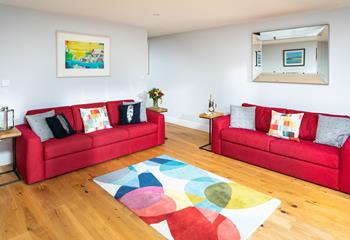 Vibrant textile sofas and an abstract rug and artwork have created a fantastic vibe in the sitting room.