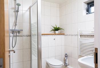 The en suite is light and spacious, with the advantage of a heated towel rail. 