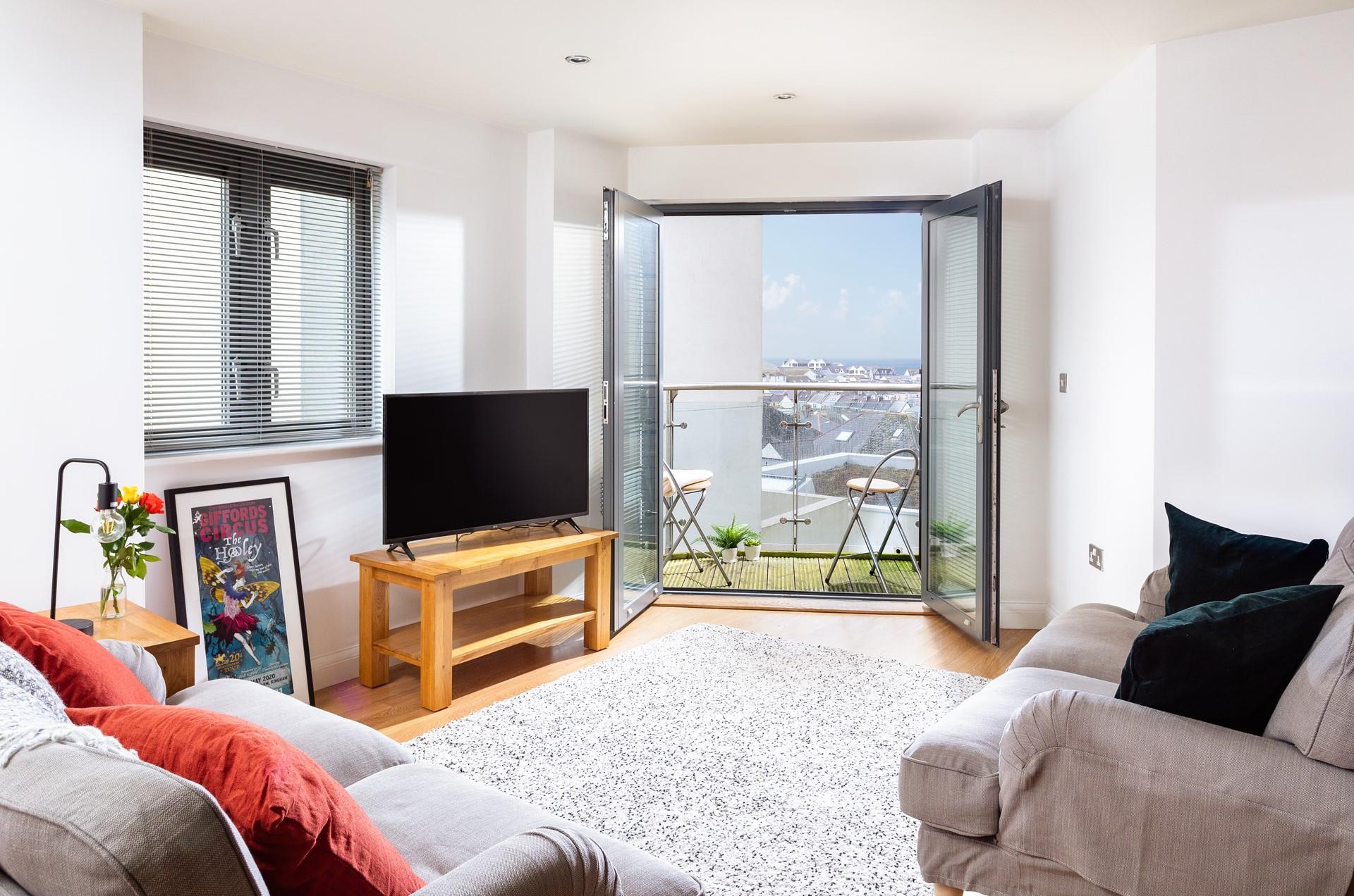 Relax in the comfortable living area with the doors open, letting in the fresh Cornish air.