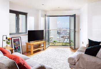 Relax in the comfortable living area with the doors open, letting in the fresh Cornish air.