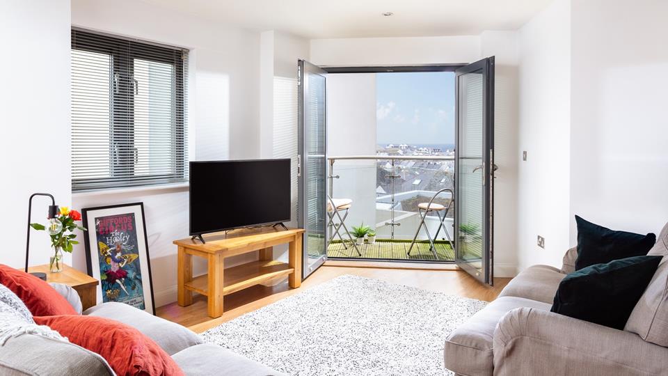 Relax in the comfortable living area with the doors open, letting in the fresh Cornish air.