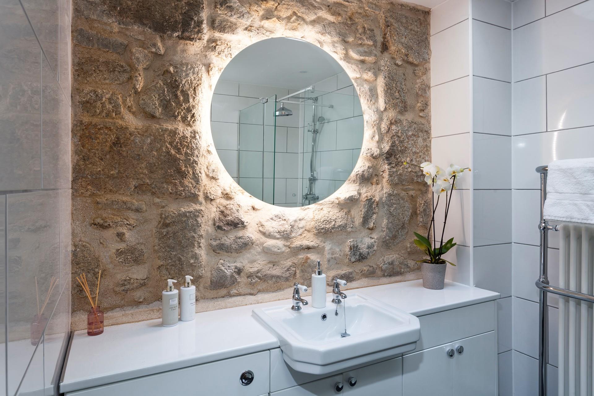 The modern kitchen has a beautiful light-up mirror, the perfect space to get ready in the morning.