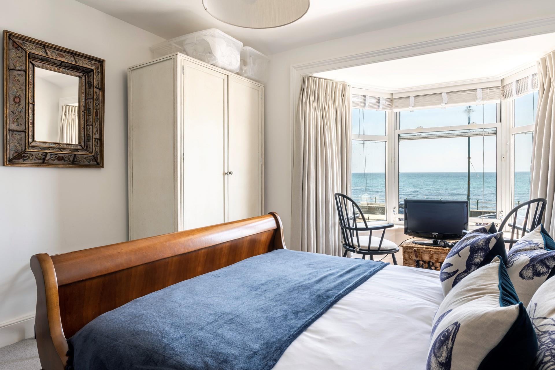 The spacious bedroom is beautifully decorated with a deep blue and cream theme.