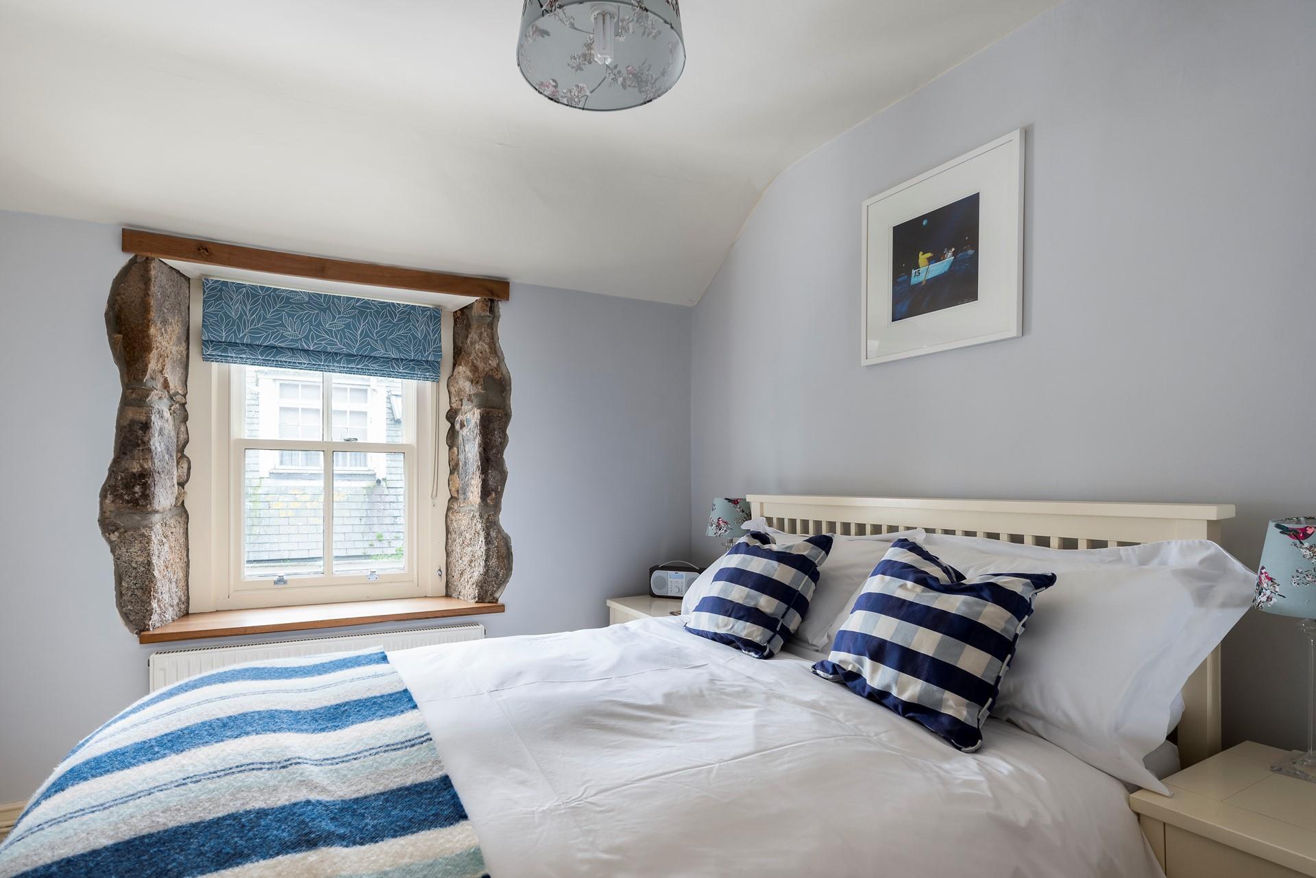 We love the exposed granite around the window, adding character to this comfortable bedroom. 