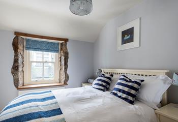 We love the exposed granite around the window, adding character to this comfortable bedroom. 