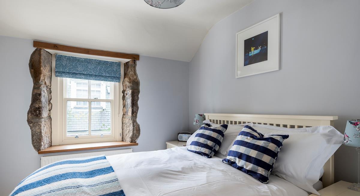 We love the exposed granite around the window, adding character to this comfortable bedroom. 