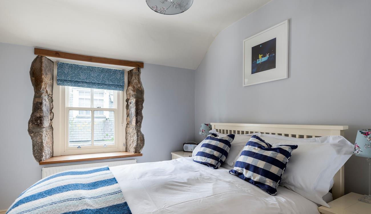 We love the exposed granite around the window, adding character to this comfortable bedroom. 