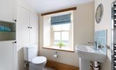 The character of the cottage continues into the family shower room, with an exposed beam and a deep window sill.  - Thumbnail Image