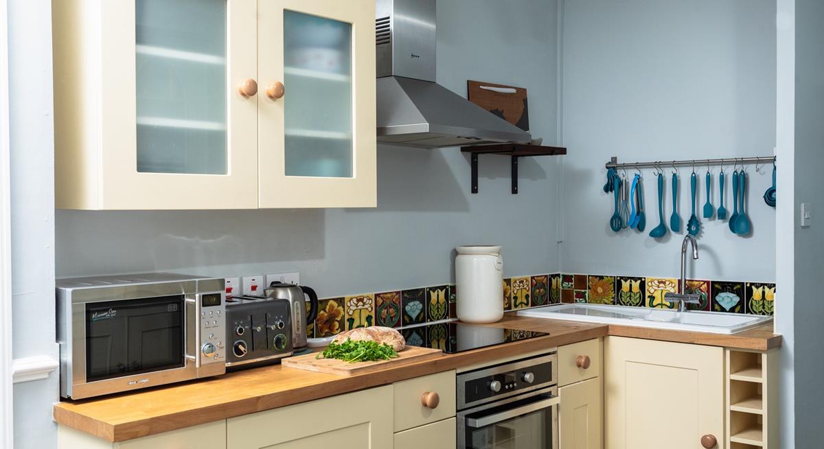 Finished in cream and pastel blues, with slate flooring, the kitchen has a countryside vibe. 