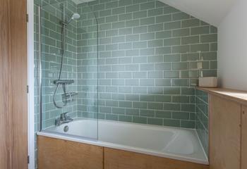 The family bathroom, also finished in pastel green tiles, is ideal for washing off those sandy feet!