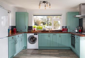 The stylish kitchen is fully equipped with everything you could need to rustle up a Cornish feast. We love the colour!