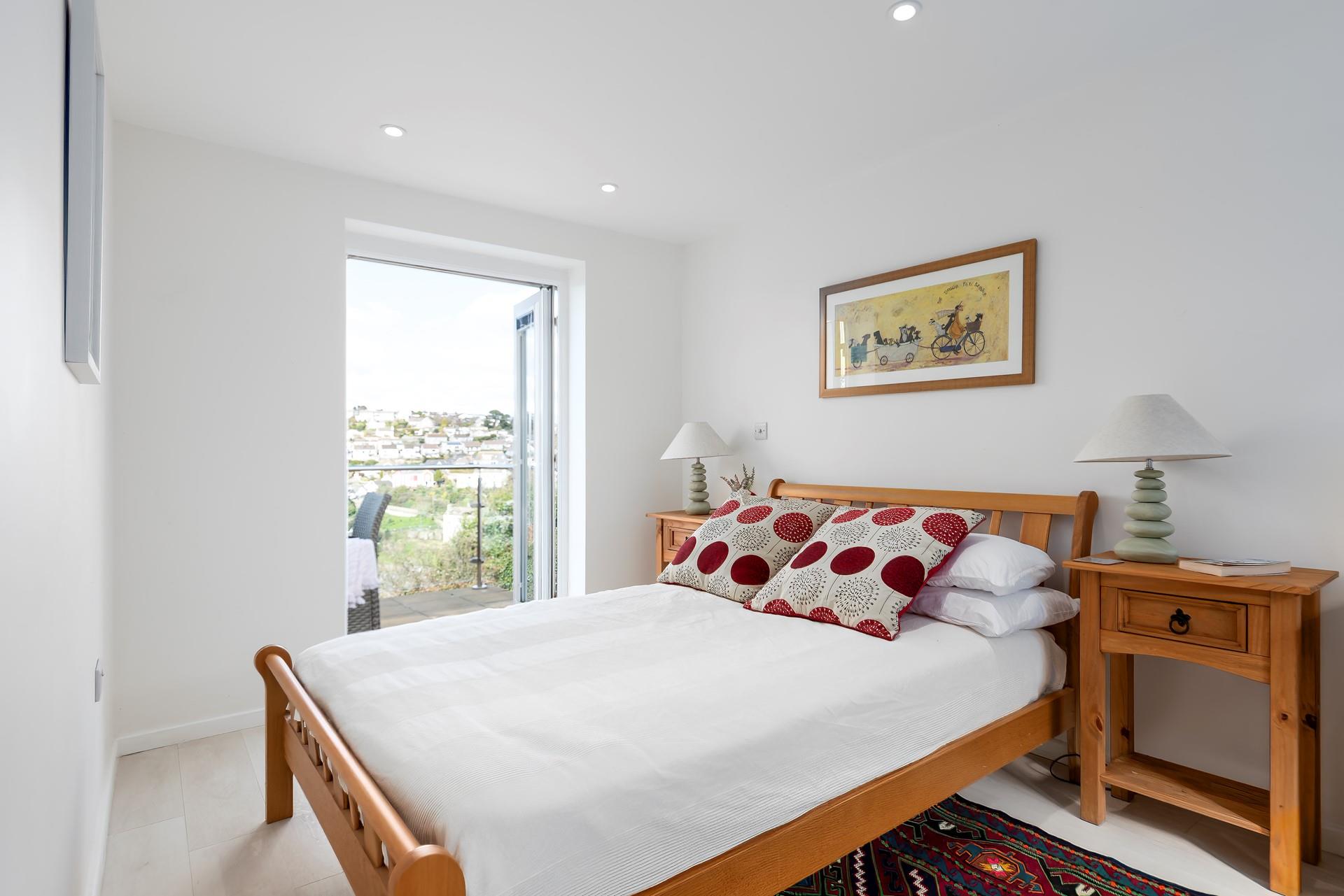 Bedroom 1 benefits from direct access to the balcony; throw open the door and wake up to the sound of the sea in the distance. 