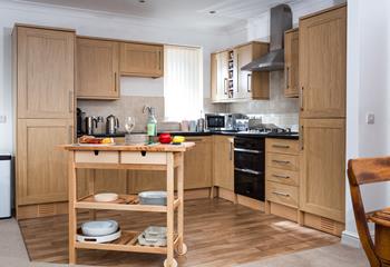 The country-style kitchen is beautifully designed and fully equipped with modern appliances to make whipping up tasty meals a breeze.