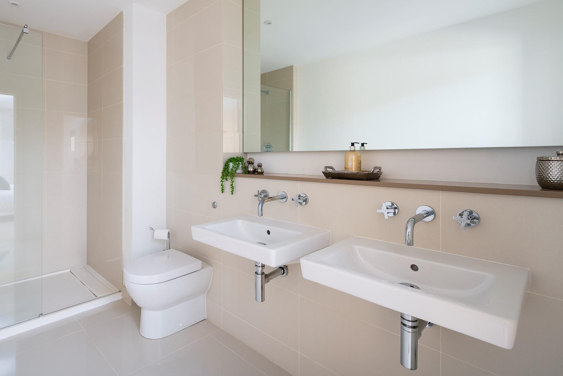 Twin sinks add a touch of luxury to the en suite shower room, which is complete with a rainfall shower. 