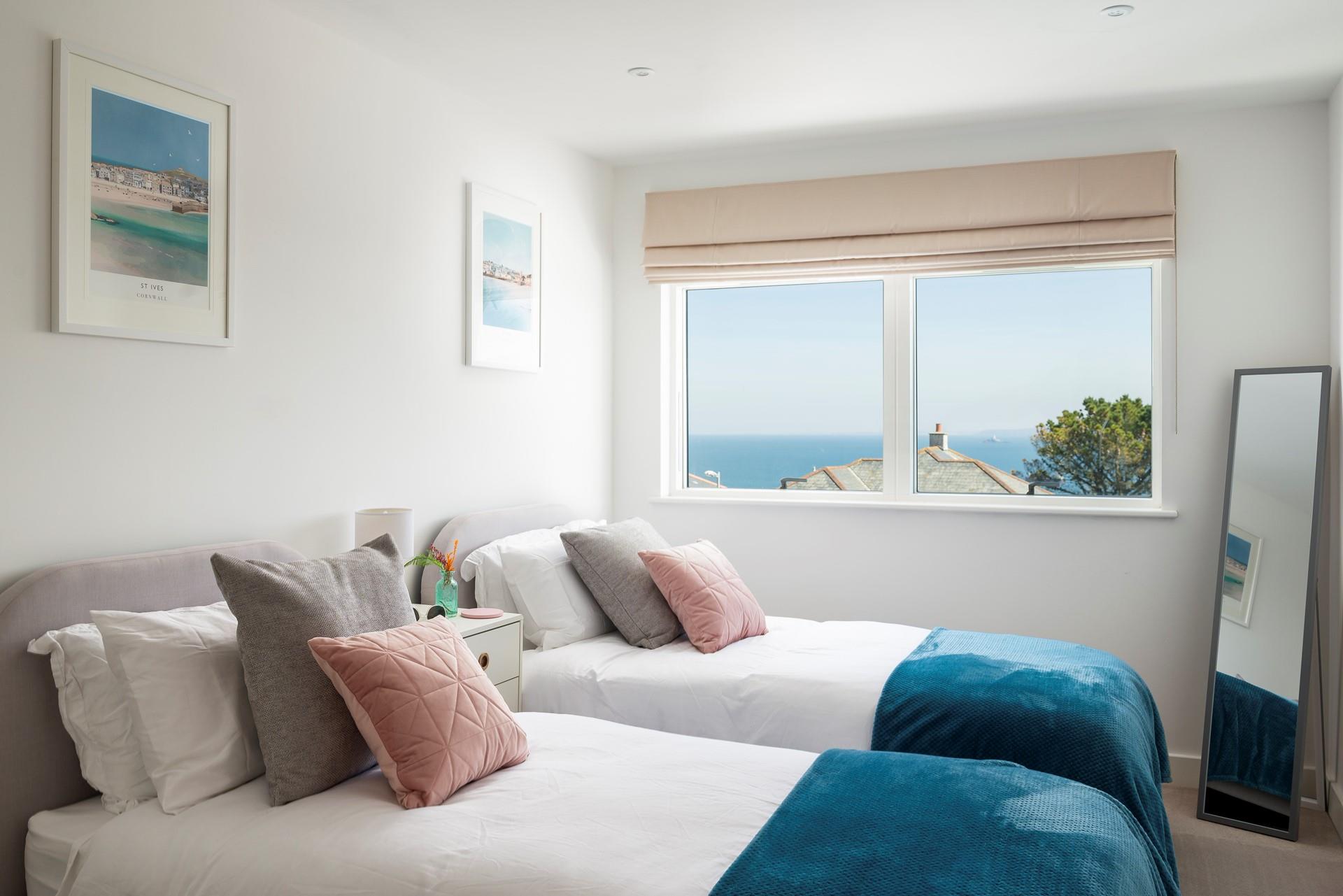 Filled with natural light from the large window, the twin bedroom is bright and welcoming.