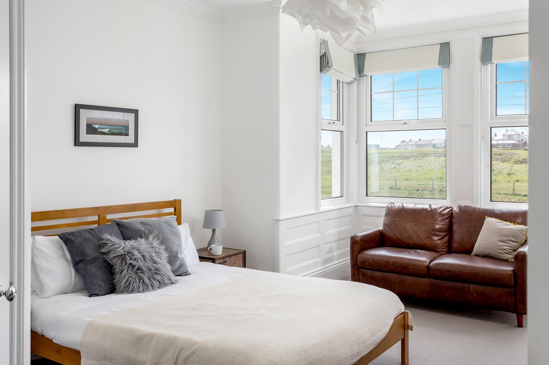 Bedroom 4 has a king size bed and views of the golf course and across to Crooklets beach.