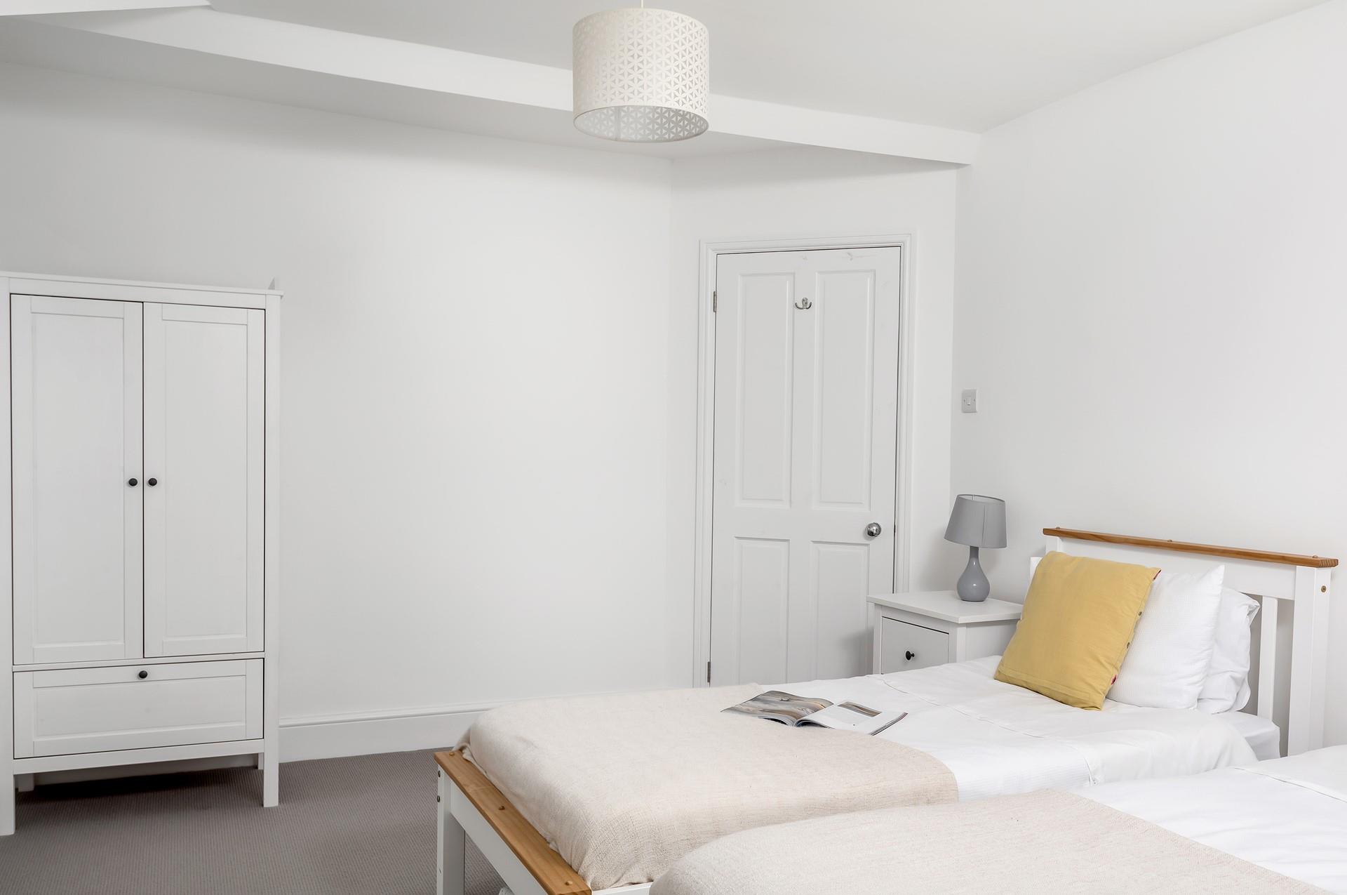 Bedroom 1 has a pop of colour with the yellow comfy cushions.