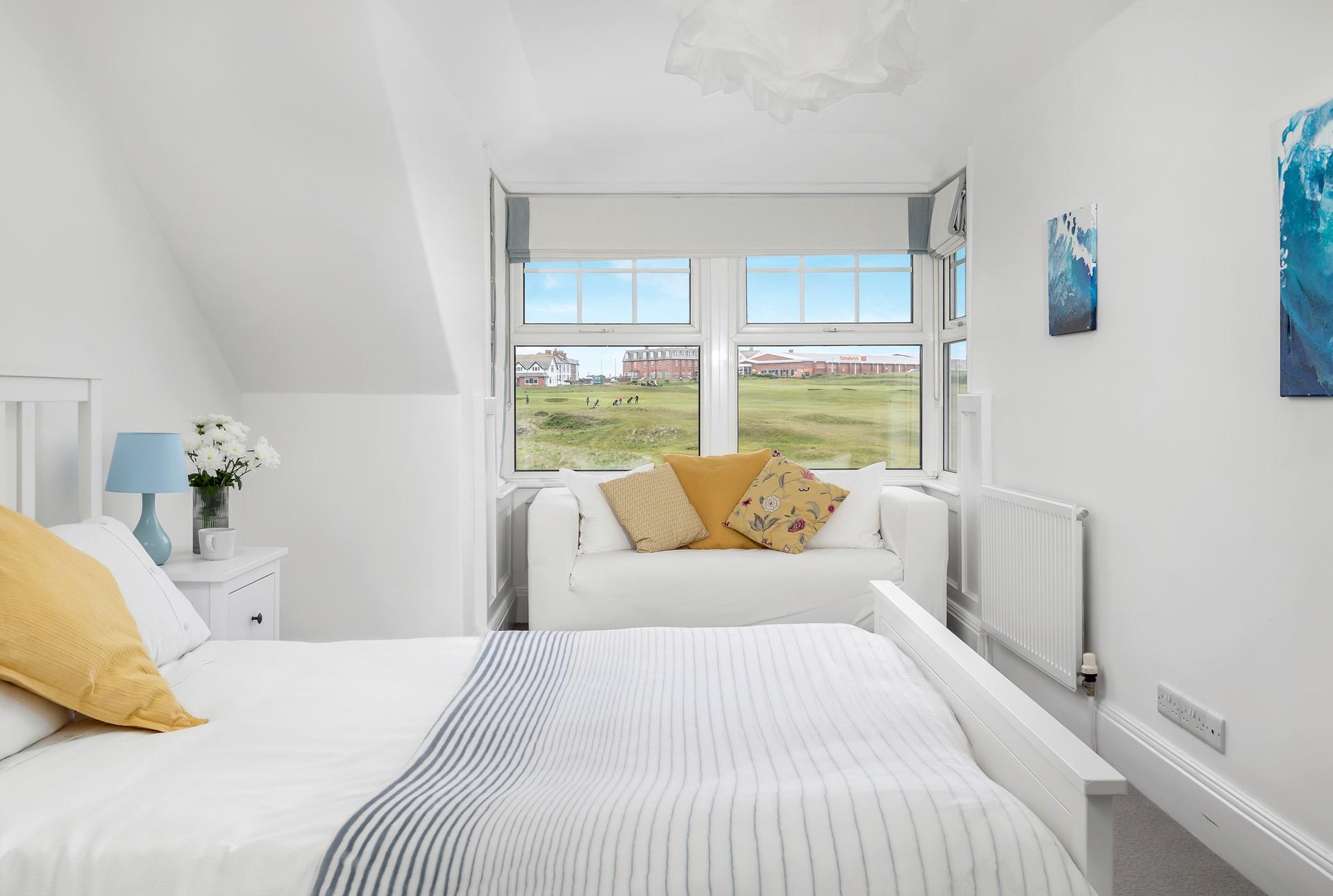 Bedroom 6 has a king size bed and sofa for enjoying a quiet moment reading a book.