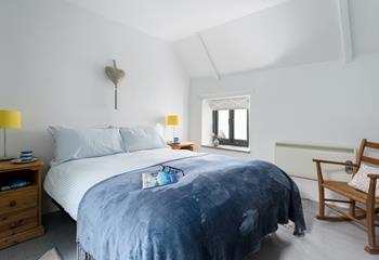 Light and spacious, the double bedroom benefits from a high ceiling. 