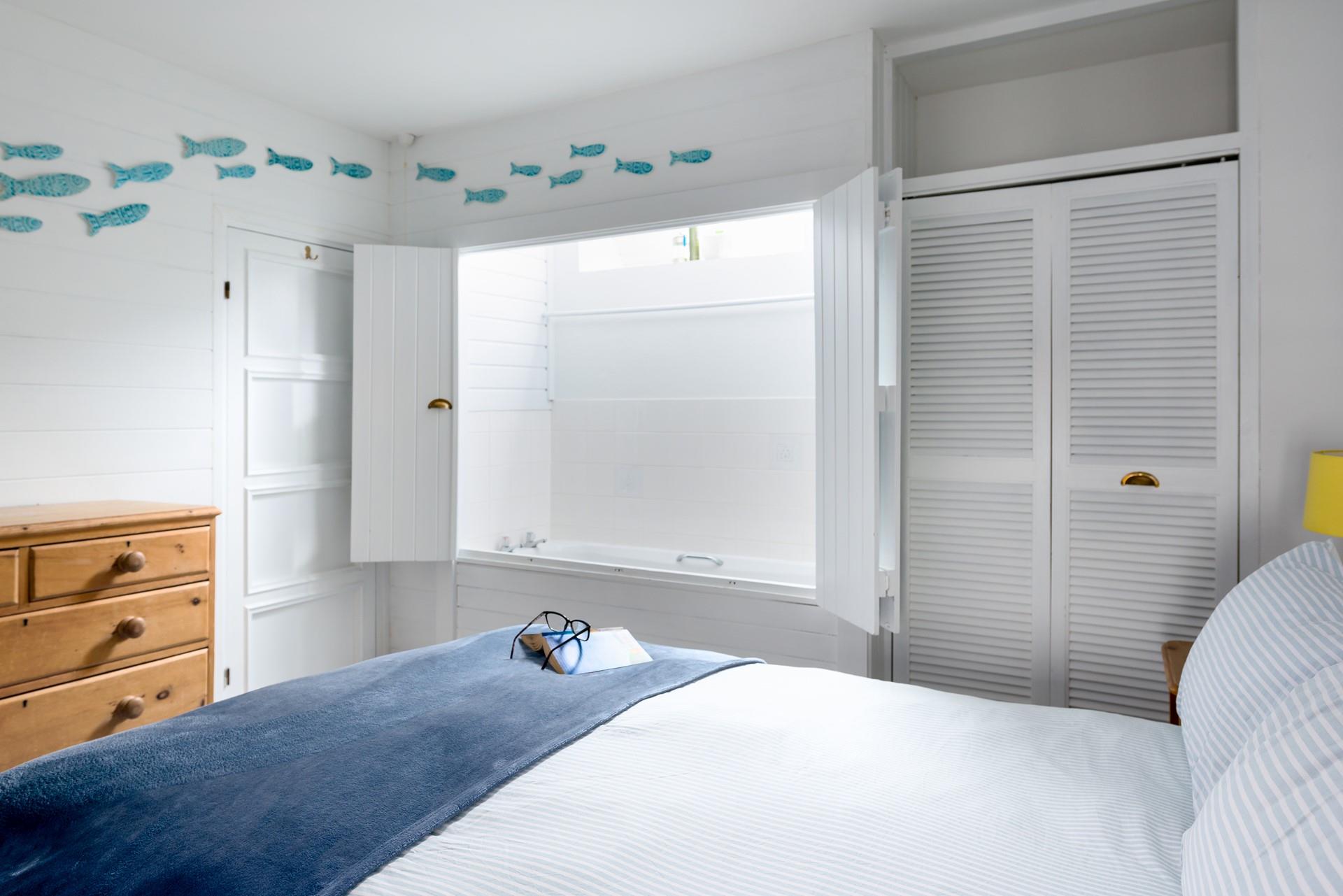 This bedroom has a surprising feature - a bath hidden behind cupboard doors!