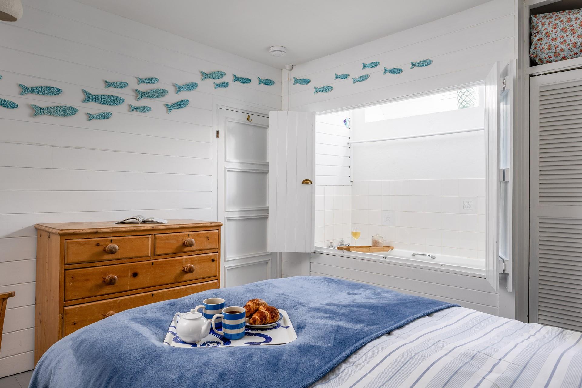 Bedroom 1 has a surprising feature - a bath hidden behind cupboard doors!