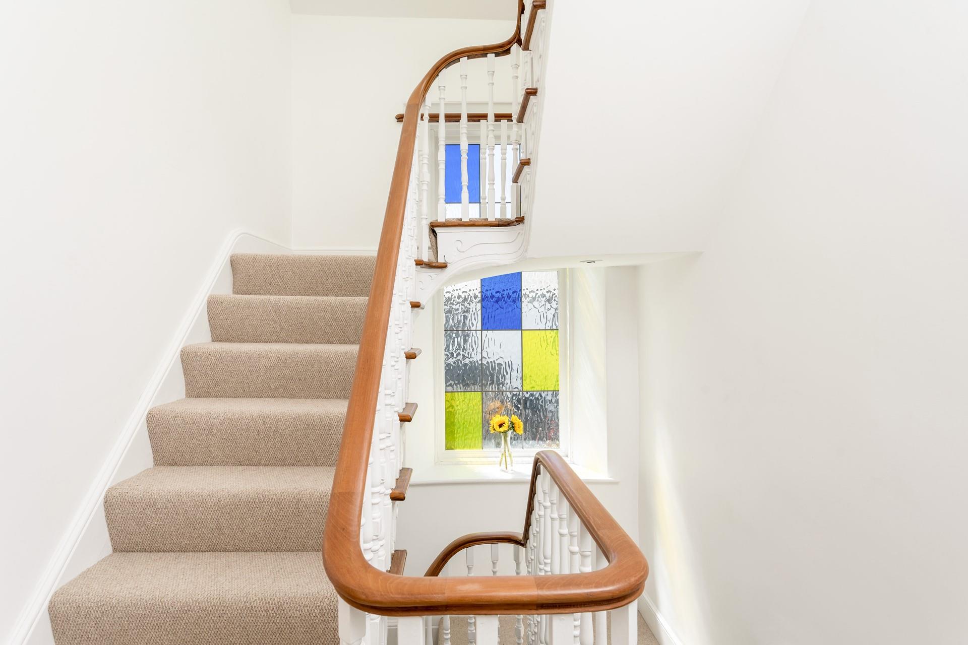 Sweeping staircases and beautiful stained glass windows, add to the wow factor of this beautiful house.