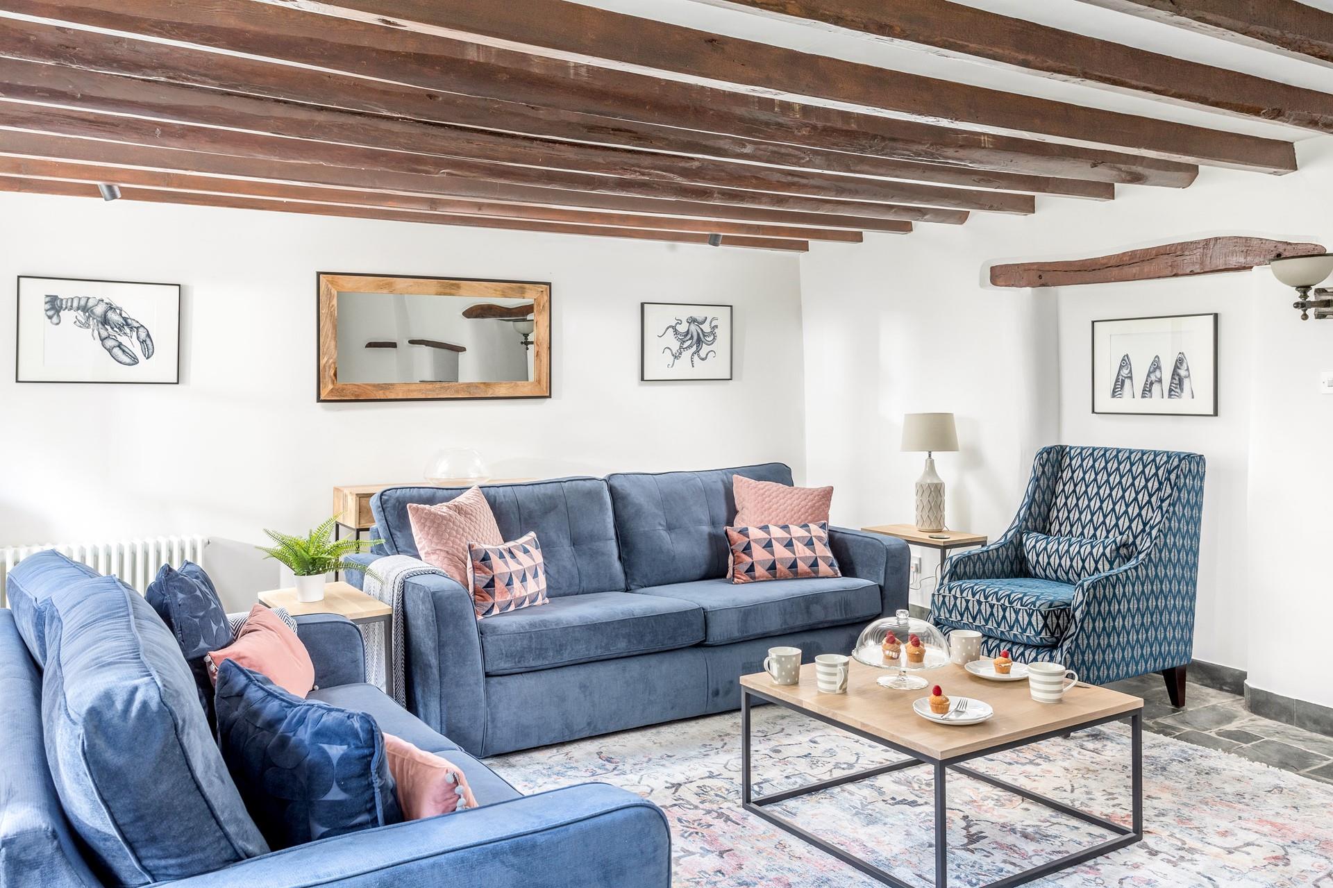 The sitting room has charming cottage features with its exposed beams and slate floors.