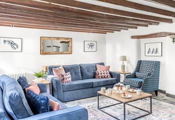 The sitting room has charming cottage features with its exposed beams and slate floors.