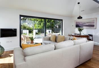 Relax together on the large sumptuous sofa, taking in the garden views. 
