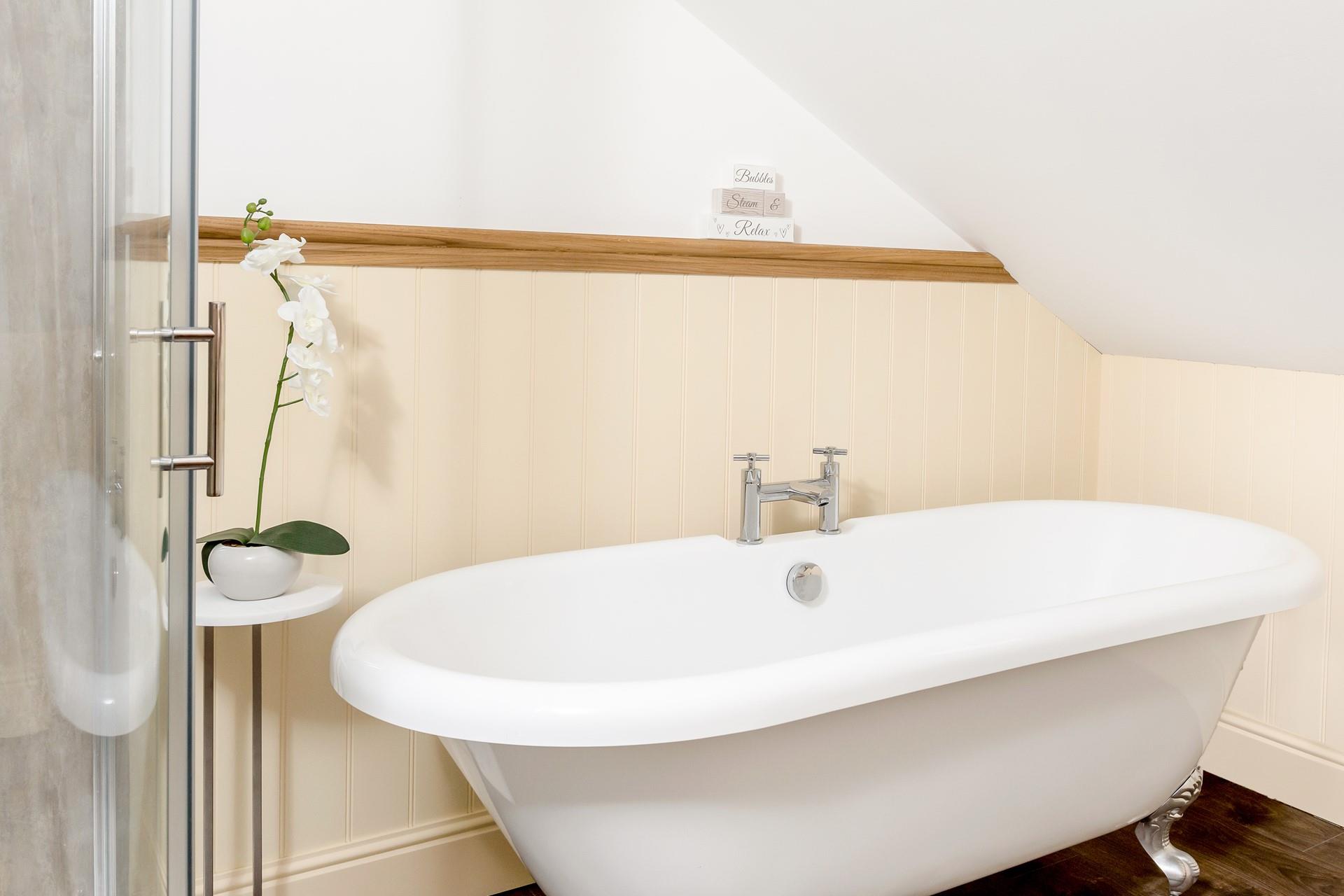 The family bathroom has a freestanding bath and an enclosed shower for washing sandy toes or for relaxing baths.