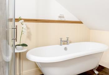 The family bathroom has a freestanding bath and an enclosed shower for washing sandy toes or for relaxing baths.