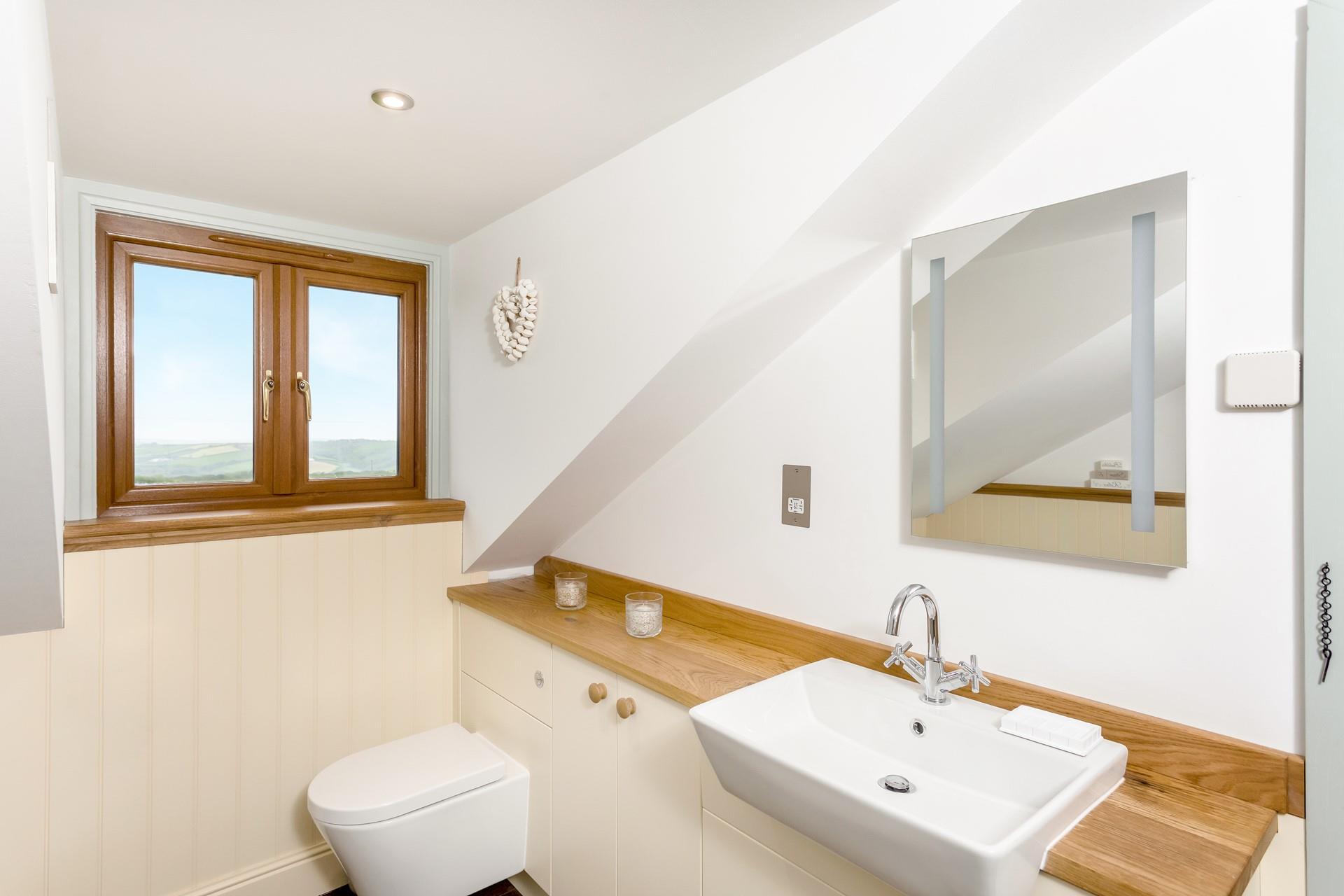 The family bathroom has an illuminated mirror for getting ready, the window overlooks the beautiful countryside.