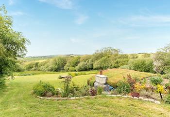 The garden area has a quirky hobbit house, perfect for enjoying the countryside views.