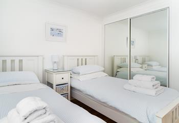 Bedroom 2 features twin beds to rest after a busy beach day.