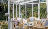 The sunny conservatory leads down to a quaint stream. - Thumbnail Image