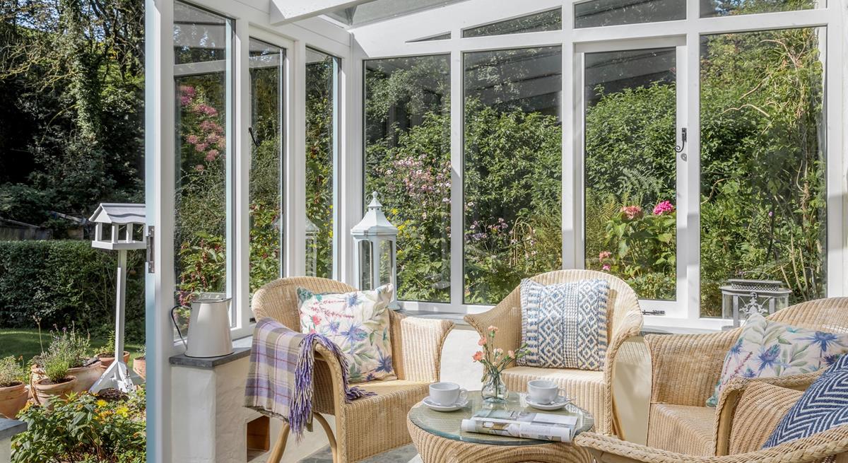 The sunny conservatory leads down to a quaint stream.