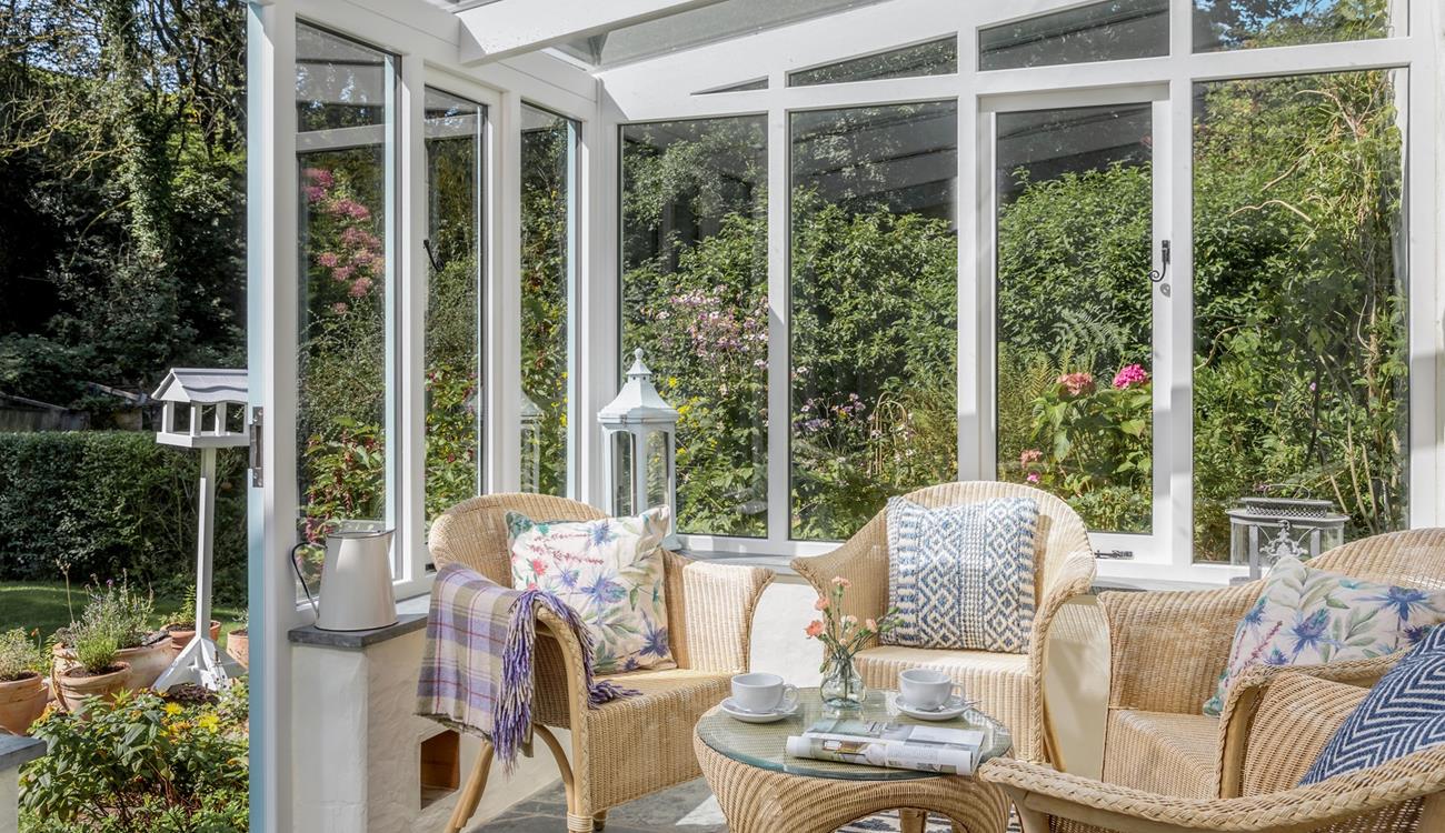 The sunny conservatory leads down to a quaint stream.
